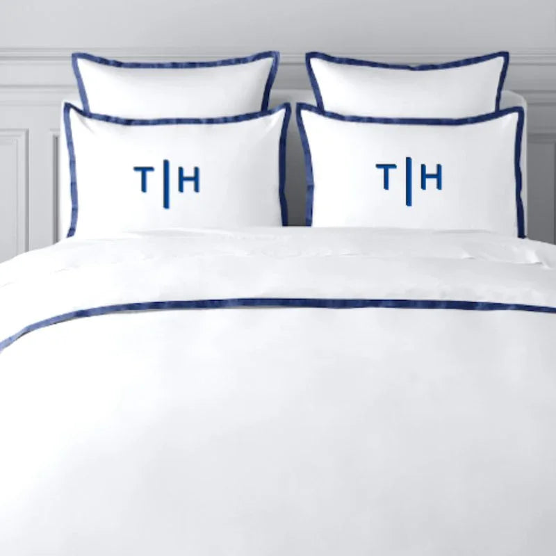 TYPEFACE 3 white percale bedding with navy blue border and navy monogram pillowcases
