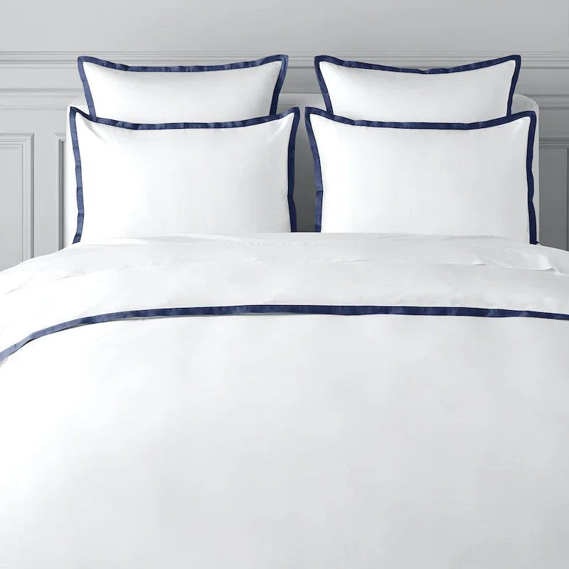 TYPEFACE 3 white percale bed sheet set with navy blue border, shown without monogram