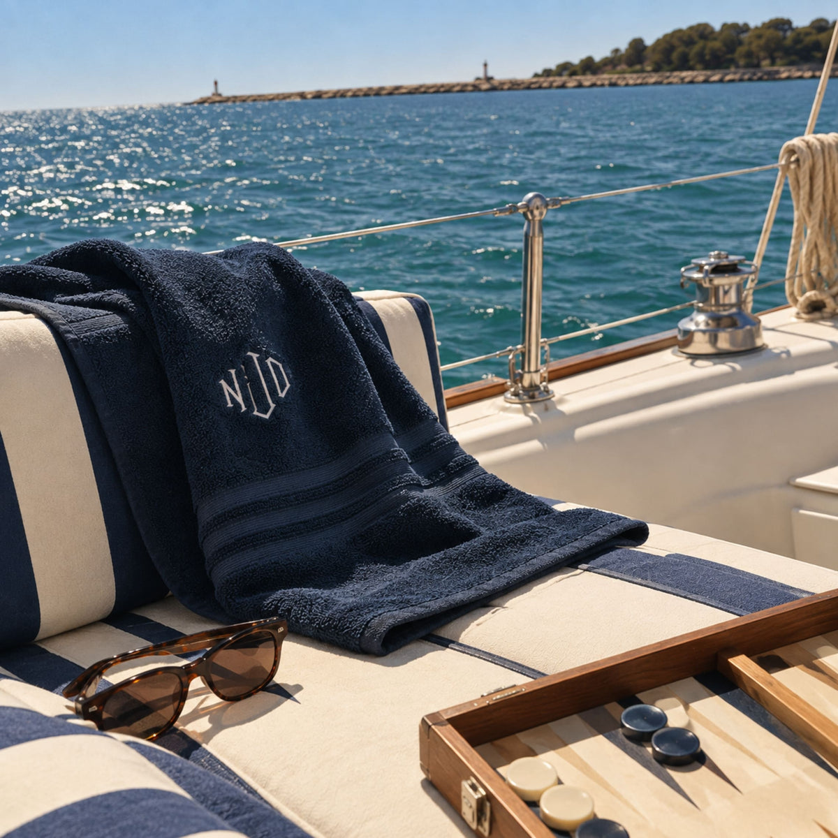 Navy blue organic cotton monogram bath towel with embroidered initials on a boat deck – BEDLAM